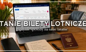 Laptop z wyszukiwarką lotów, paszport i notatnik z listą rzeczy do spakowania. Sprytne sposoby na tanie latanie.