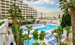 Luksusowy hotel z basenem i leżakami, idealny na wakacje all inclusive w Barcelonie.