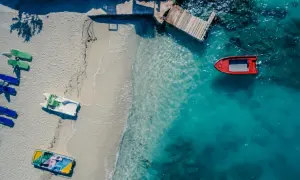 Widok z lotu ptaka na plażę w Albanii z łodziami i turkusową wodą.