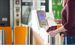 Odprawa lot czarterowy: kobieta z paszportami i biletami przy bramce bezpieczeństwa.