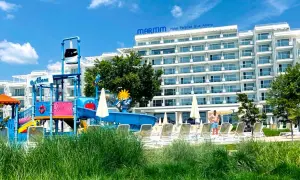 Kolorowy aquapark i hotel Maritim Paradise Blue Albena w Bułgarii, z leżakami i zieloną trawą.