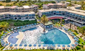 Relaks przy basenie w Cathrin Hotel Rodos. Goście odpoczywają na leżakach pod parasolami, niektórzy pływają w turkusowej wodzie.