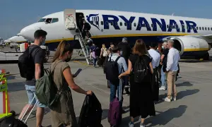Kolejka do samolotu Ryanair. Pasażerowie z bagażami czekają na boarding ile przed odlotem.