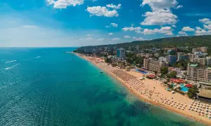 Słoneczna plaża z mnóstwem leżaków i turystów, turkusowe morze, hotele i zielone wzgórza. Warna, co zobaczyć!