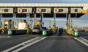 Samochody zbliżają się do bramek poboru opłat za autostrady. Widać znaki eTOLL i ograniczenia wysokości 2,0m.