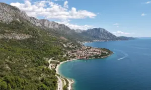 Widok na wybrzeże Chorwacji z górami i miasteczkiem. Idealne miejsce na wakacje, gdzie można kupić winiety do Chorwacji.