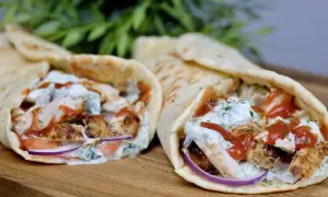 Dwa pyszne souvlaki w picie z kurczakiem, warzywami i sosem, gotowe do zjedzenia.
