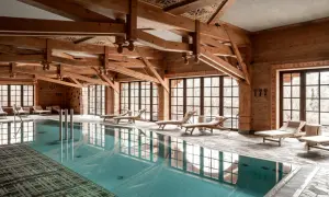 Drewniane belki, basen i leżaki tworzą atmosferę luksusowego spa.