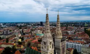Dwie wieże katedry górują nad miastem. W oddali widać nowoczesne budynki i zielone tereny. To wspaniałe zagrzeb atrakcje.