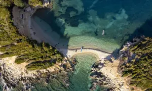 Albania, styczeń. Pogoda sprzyja wodnym aktywnościom na malowniczej plaży z turkusową wodą i kajakami.