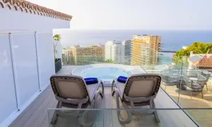 Relaks na tarasie z jacuzzi i widokiem na ocean w Fergus Puerto de la Cruz. Dwa leżaki czekają na gości.