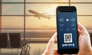 Bilet lotniczy na telefonie: NYC do LHR, pasażer John, lot LP418. IATA co to? To kod lotniska.