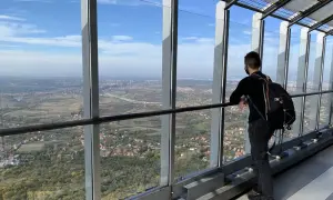 Widok z wieży na Belgrad, stolicę Serbii. Mężczyzna z plecakiem podziwia panoramę miasta i okolic.
