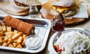 Sycące dania kuchni serbskiej: panierowany rolka mięsa z frytkami, burger i sałatka.