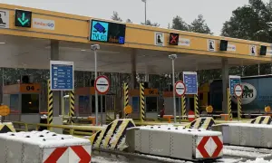 Oznaczenia na bramkach na autostradzie AmberGO: zielona strzałka w dół, czerwony krzyżyk, informacja o poborze opłat.