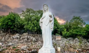 Biały posąg Matki Bożej na skalistym wzgórzu, miejsce pielgrzymek do Medjugorie.