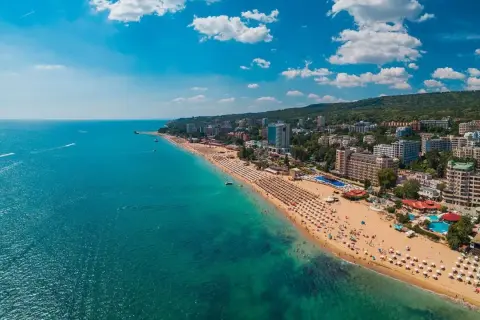 Słoneczna plaża z mnóstwem leżaków i turystów, turkusowe morze, hotele i zielone wzgórza. Warna, co zobaczyć!