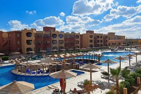 Casa Mare Resort (dawniej Royal Tulip Beach Resort) z basenami, leżakami i palmami pod błękitnym niebem.