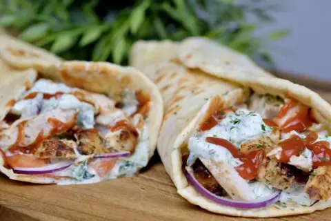 Dwa pyszne souvlaki w picie z kurczakiem, warzywami i sosem, gotowe do zjedzenia.