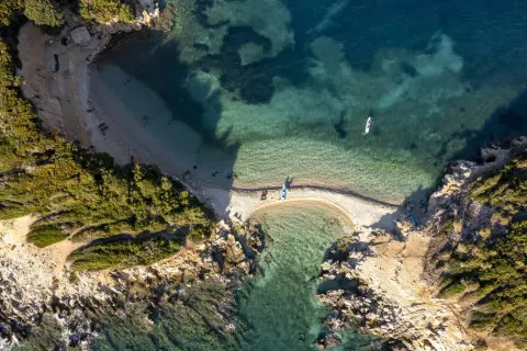 Albania, styczeń. Pogoda sprzyja wodnym aktywnościom na malowniczej plaży z turkusową wodą i kajakami.