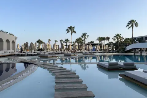 Luksusowy basen z leżakami i palmami, idealny na laur hotel experience. Elegancja laur hotels w każdym detalu.