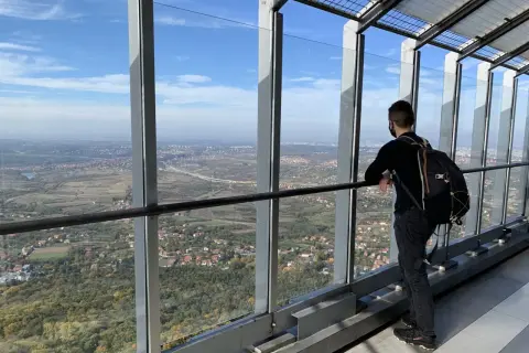 Widok z wieży na Belgrad, stolicę Serbii. Mężczyzna z plecakiem podziwia panoramę miasta i okolic.