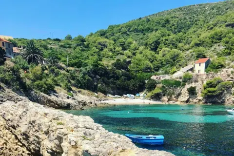 Ukryta zatoczka z turkusową wodą, kamienistą plażą i domkami na wzgórzu. Idealne miejsce na odkrycie mało znanych miejsc w Chorwacji.