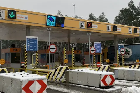Oznaczenia na bramkach na autostradzie AmberGO: zielona strzałka w dół, czerwony krzyżyk, informacja o poborze opłat.
