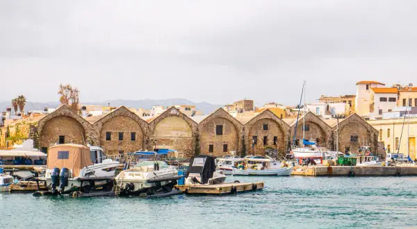 Port w Chanii, z łodziami i zabytkowymi budynkami, to jedna z głównych atrakcji miasta.
