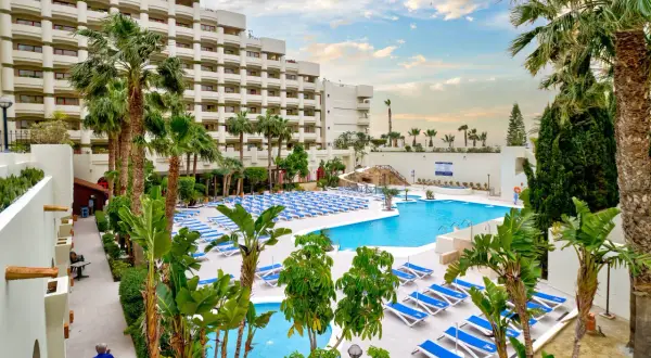 Luksusowy hotel z basenem i leżakami, idealny na wakacje all inclusive w Barcelonie.