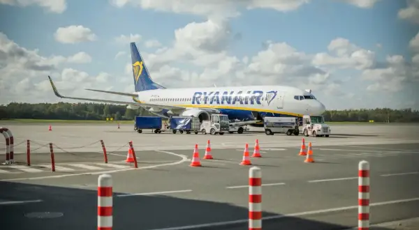 Samolot Ryanair na płycie lotniska, przygotowywany do lotu. Zastanawiasz się, ile wcześnie być na lotnisku?