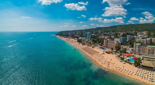 Słoneczna plaża z mnóstwem leżaków i turystów, turkusowe morze, hotele i zielone wzgórza. Warna, co zobaczyć!
