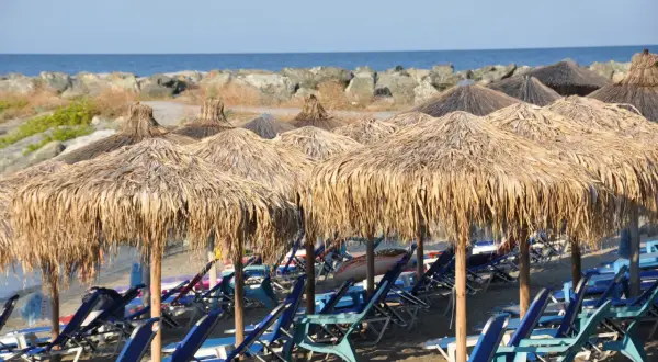 Słomiane parasole i leżaki na plaży, idealne na relaks. Riwiera Olimpijska atrakcje czekają!