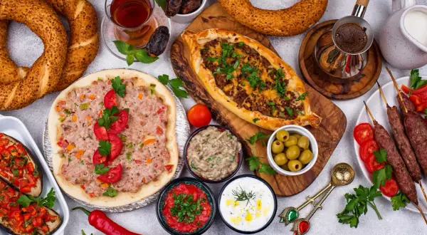 Pyszne albania jedzenie: pide, lahmacun, kebaby, bakłażany z warzywami, oliwki, dipy, chałka i herbata.