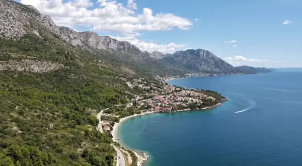 Widok na wybrzeże Chorwacji z górami i miasteczkiem. Idealne miejsce na wakacje, gdzie można kupić winiety do Chorwacji.