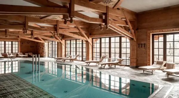 Drewniane belki, basen i leżaki tworzą atmosferę luksusowego spa.