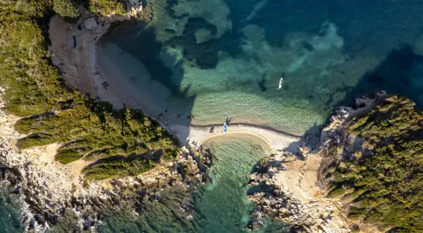 Albania, styczeń. Pogoda sprzyja wodnym aktywnościom na malowniczej plaży z turkusową wodą i kajakami.