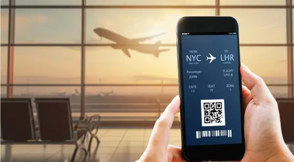 Bilet lotniczy na telefonie: NYC do LHR, pasażer John, lot LP418. IATA co to? To kod lotniska.