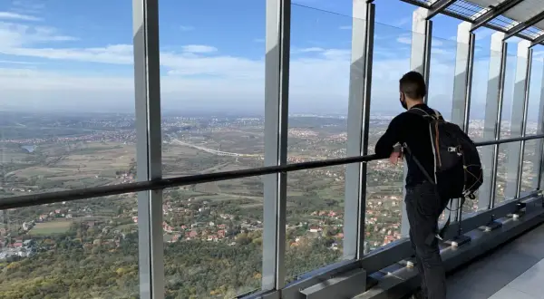 Widok z wieży na Belgrad, stolicę Serbii. Mężczyzna z plecakiem podziwia panoramę miasta i okolic.