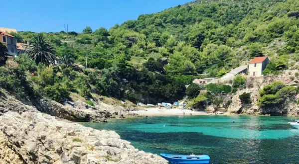 Ukryta zatoczka z turkusową wodą, kamienistą plażą i domkami na wzgórzu. Idealne miejsce na odkrycie mało znanych miejsc w Chorwacji.