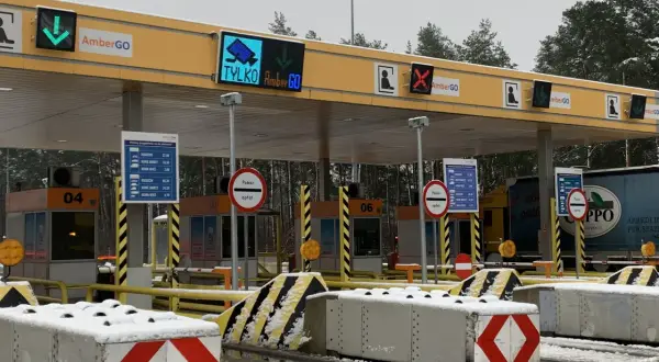 Oznaczenia na bramkach na autostradzie AmberGO: zielona strzałka w dół, czerwony krzyżyk, informacja o poborze opłat.