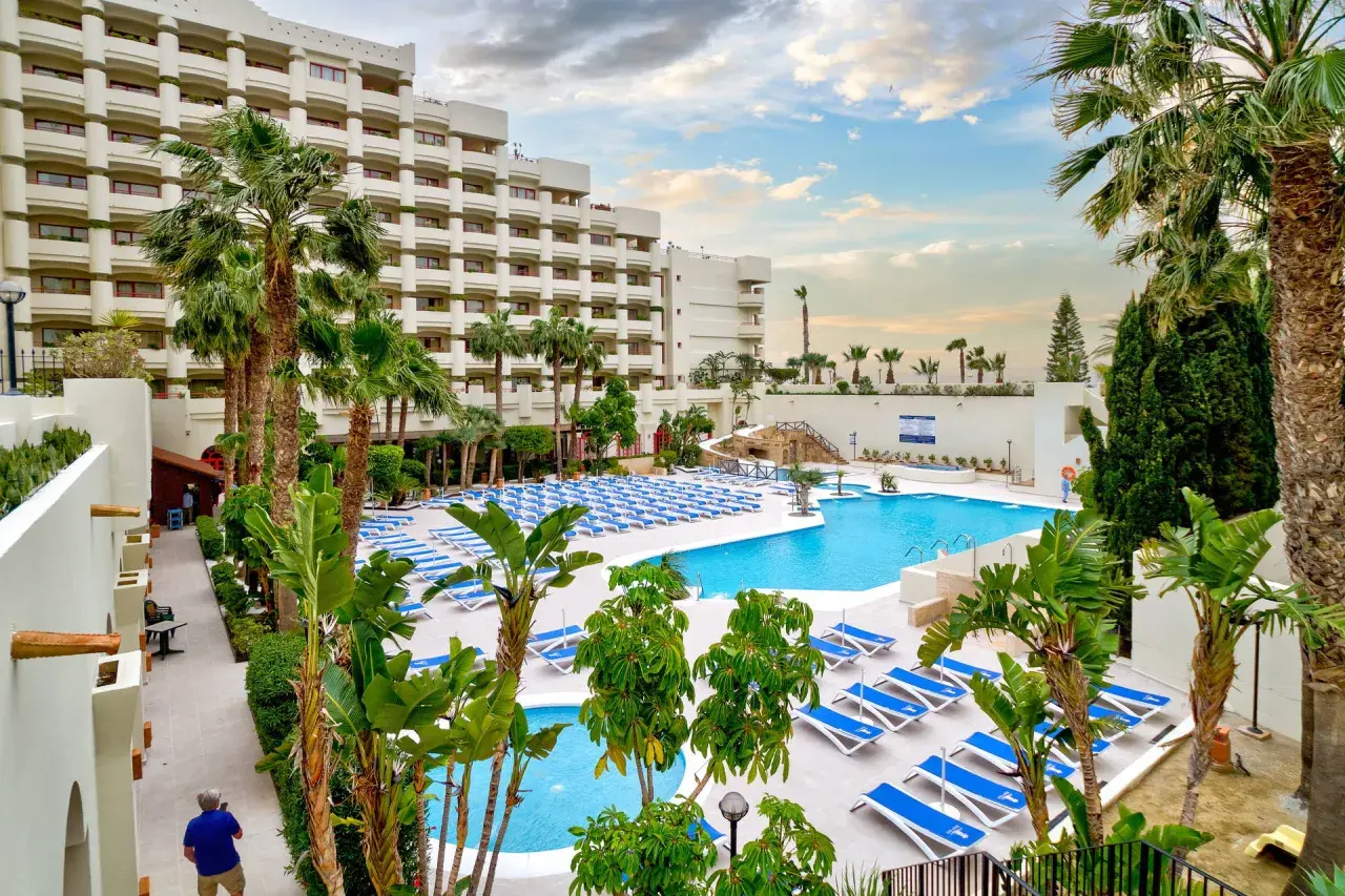 Luksusowy hotel z basenem i leżakami, idealny na wakacje all inclusive w Barcelonie.