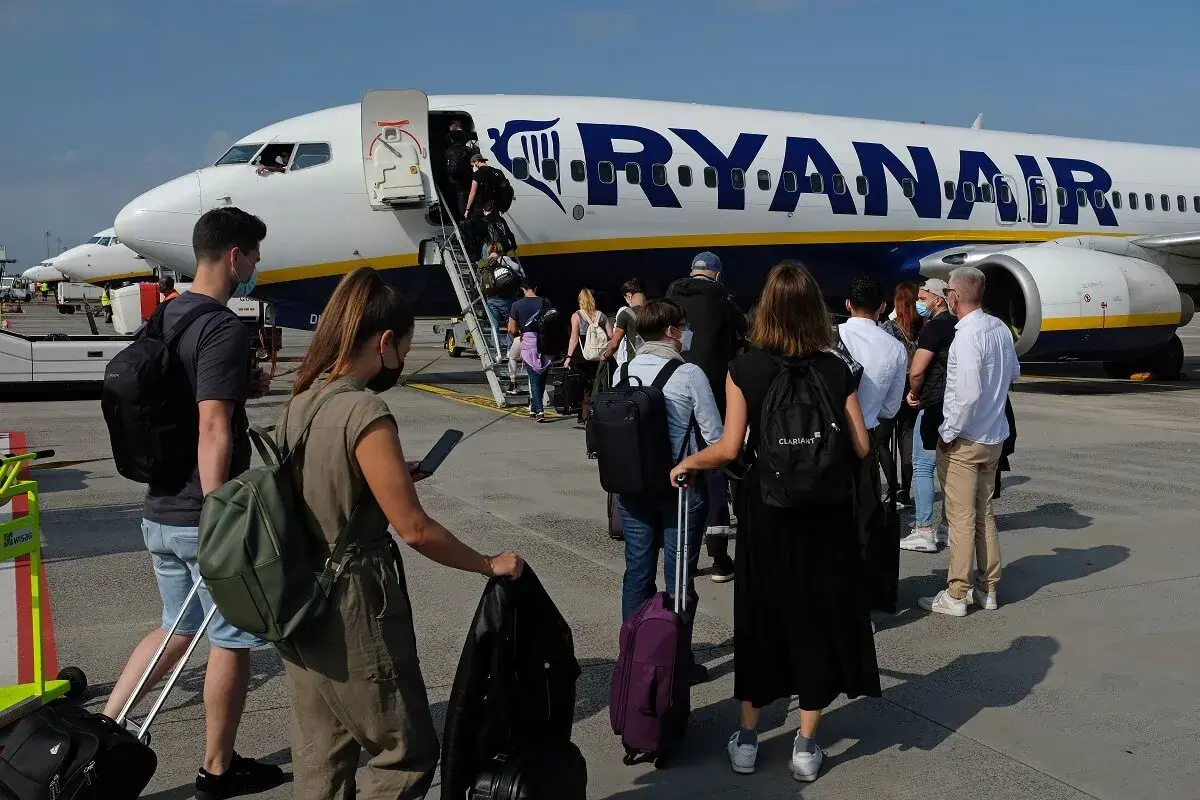 Kolejka do samolotu Ryanair. Pasażerowie z bagażami czekają na boarding ile przed odlotem.