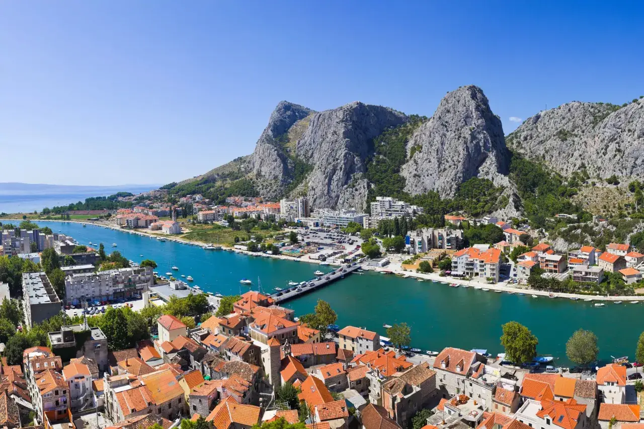 Widok na miasto Omis w Chorwacji z rzeką Cetina i górami. Czy w Chorwacji jest bezpiecznie? Tak, to spokojne miejsce na wakacje.