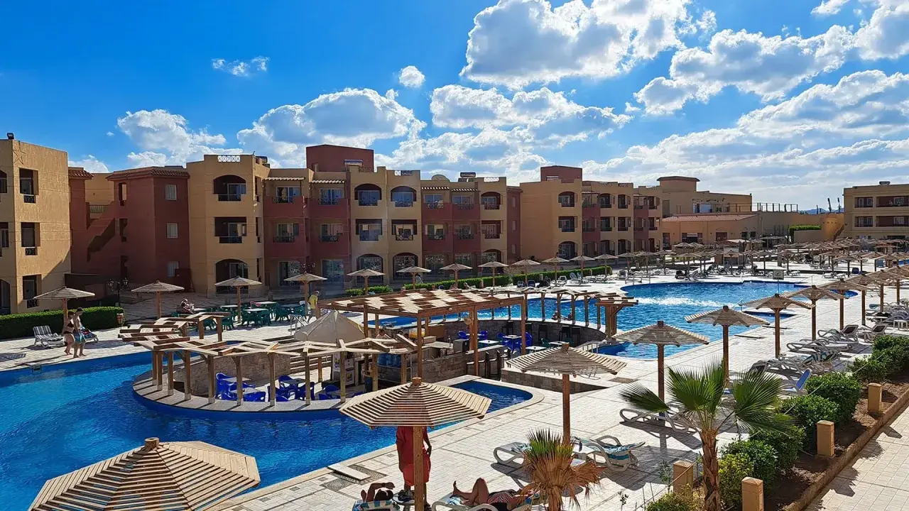 Casa Mare Resort (dawniej Royal Tulip Beach Resort) z basenami, leżakami i palmami pod błękitnym niebem.