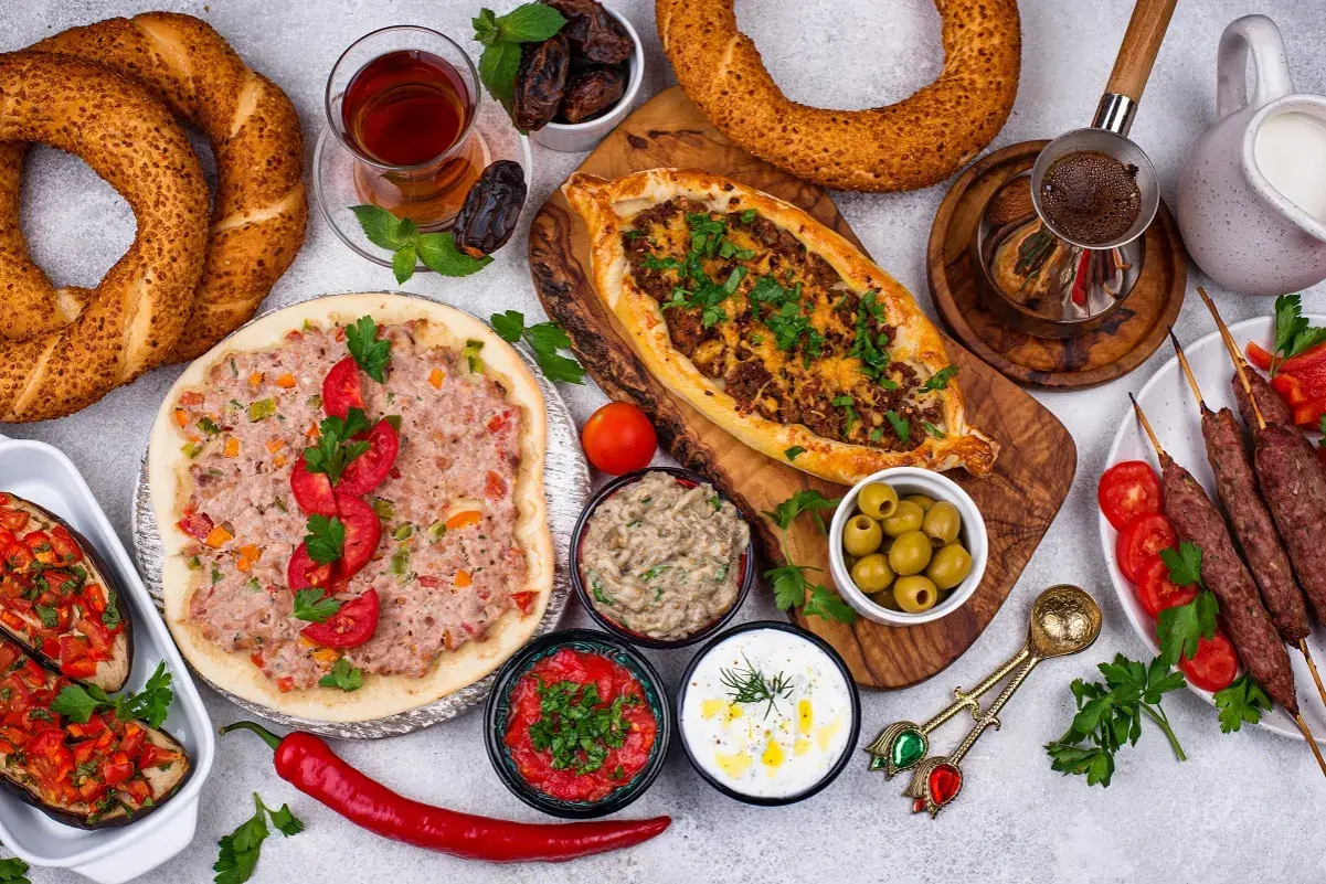 Pyszne albania jedzenie: pide, lahmacun, kebaby, bakłażany z warzywami, oliwki, dipy, chałka i herbata.