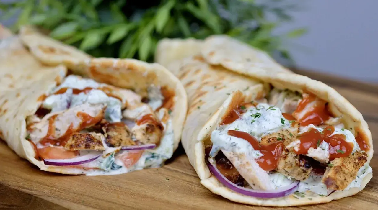 Dwa pyszne souvlaki w picie z kurczakiem, warzywami i sosem, gotowe do zjedzenia.