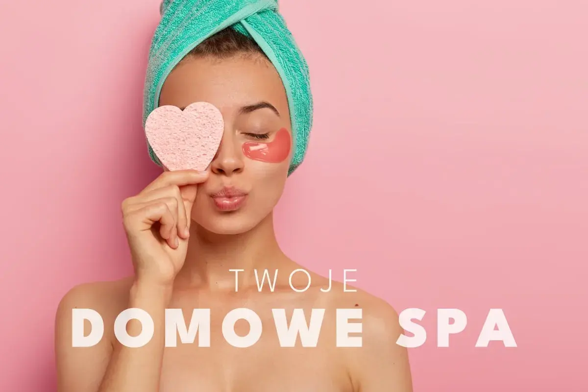 Kobieta z ręcznikiem na głowie i płatkami pod oczy trzyma serduszko. Czas na **dobre spa** w domu!