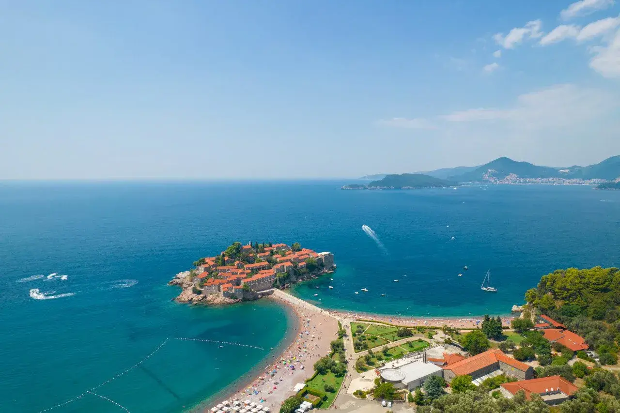 Sveti Stefan, perła czarnogórskich plaż, z malowniczą wyspą połączoną groblą.