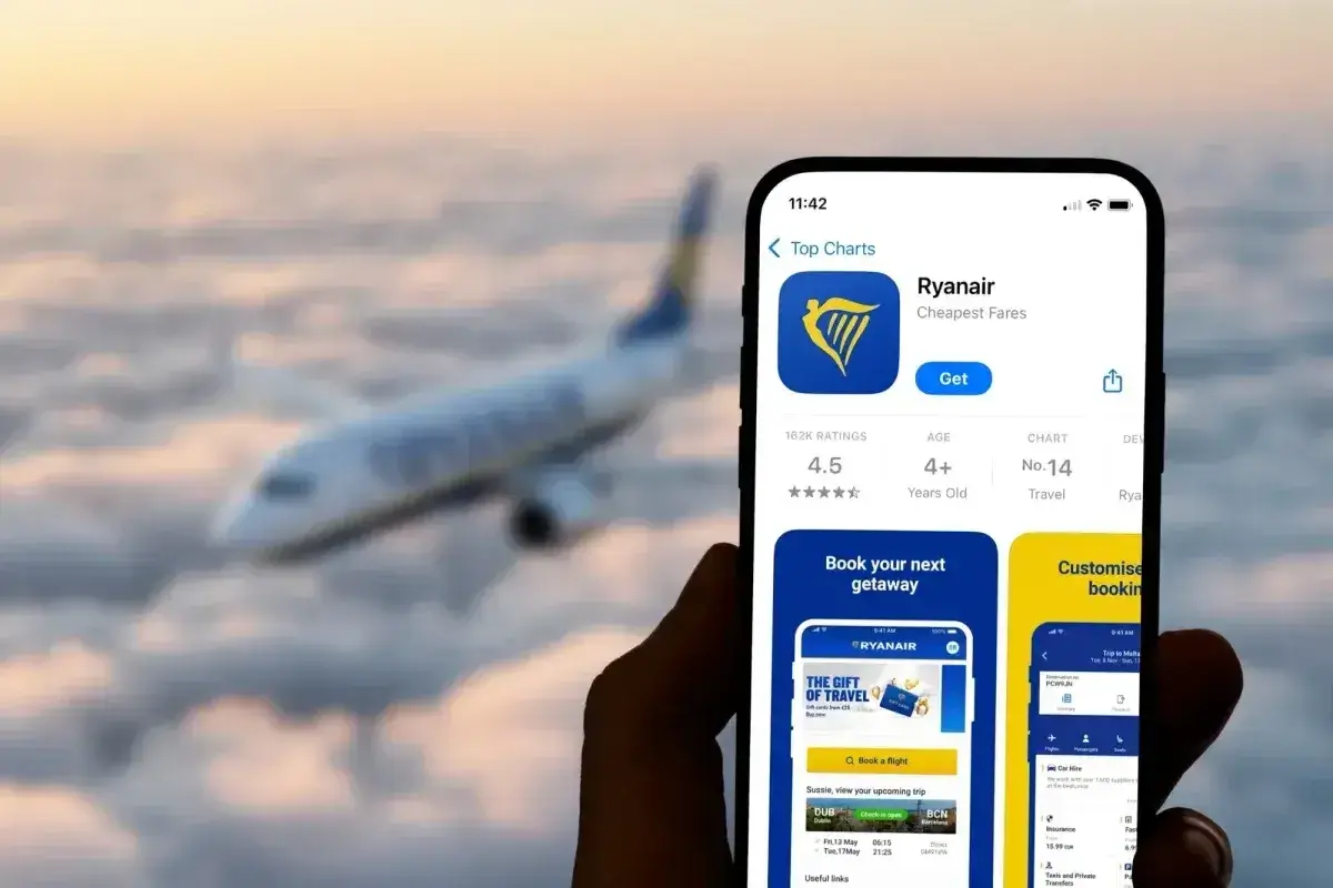Aplikacja Ryanair na telefonie, z samolotem w tle. Sprawdź, co to za aplikacja do tanich lotów.
